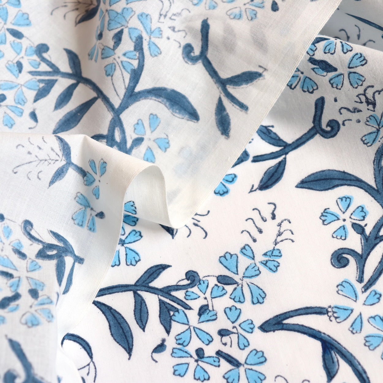 blue and white delicate floral hand block print white cotton dressmaking and quilting fabric