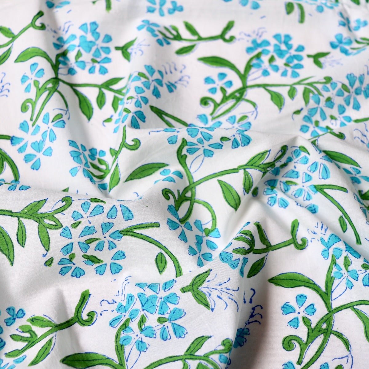 bright blue floral print cotton fabric with green leaves hand made in India