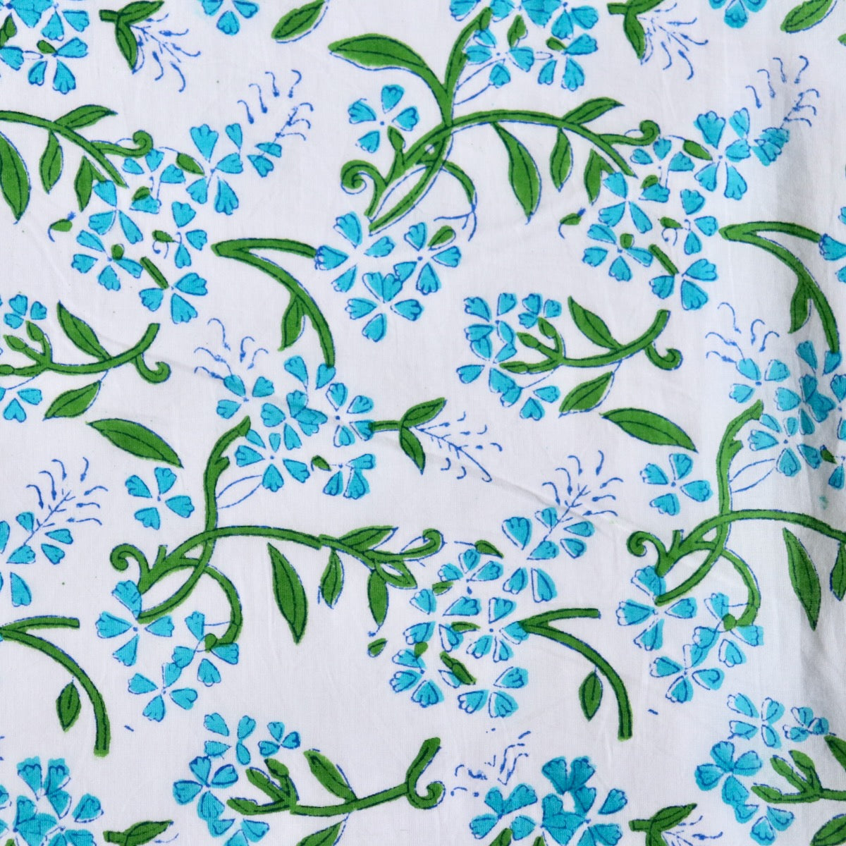 bright blue floral print cotton fabric with green leaves hand made in India
