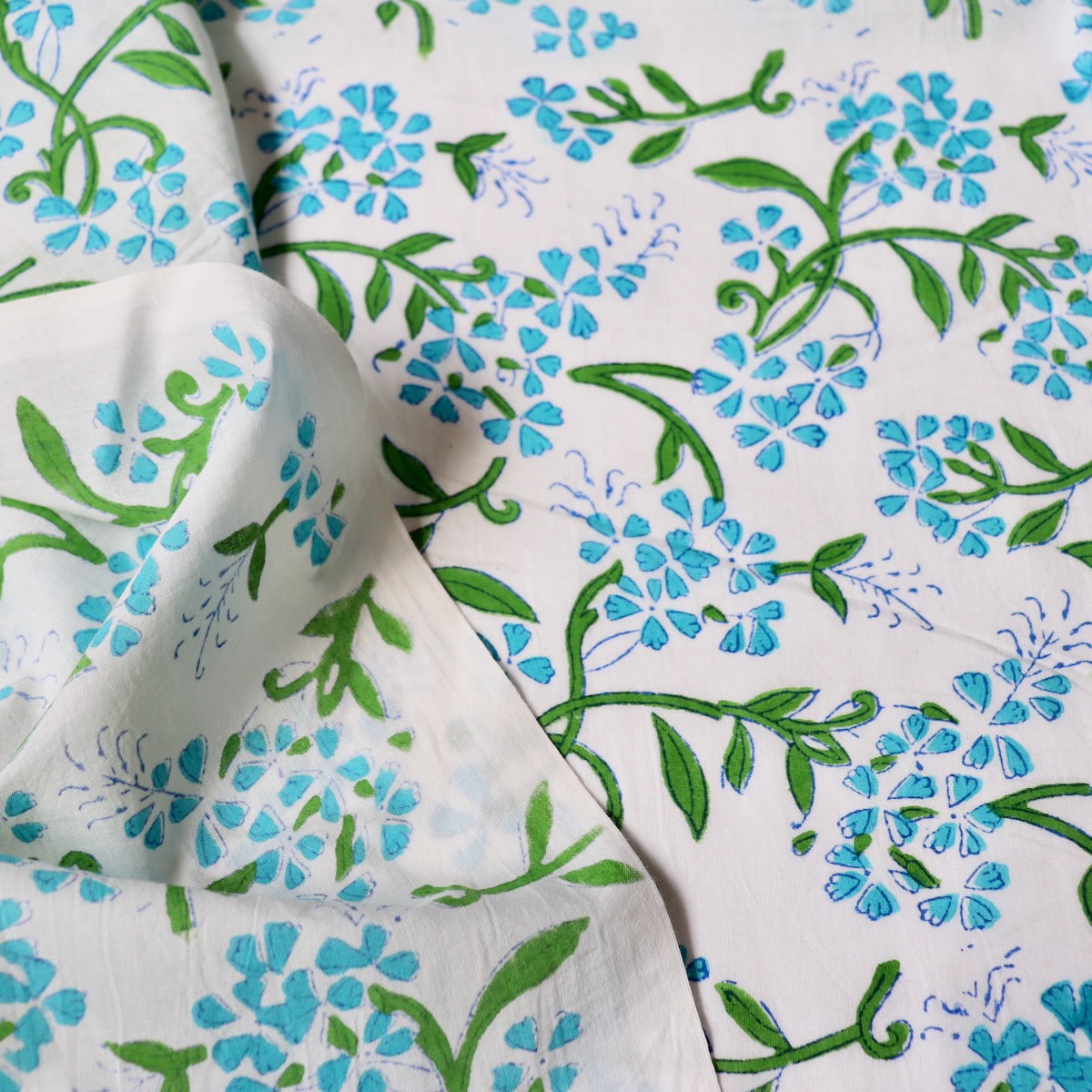 bright blue floral print cotton fabric with green leaves hand made in India