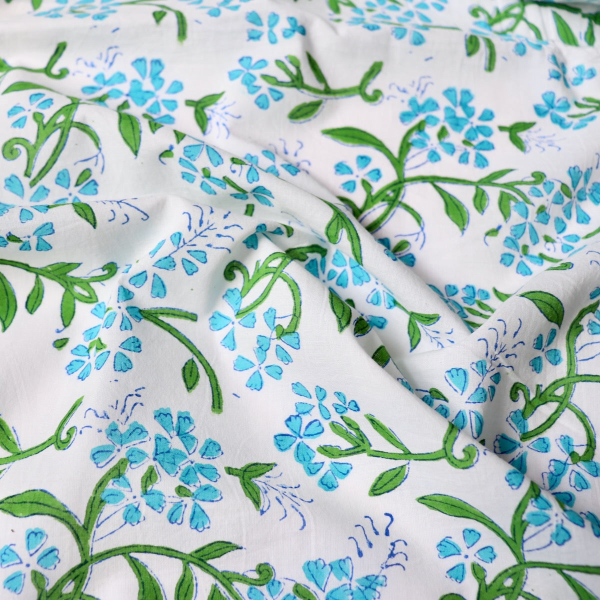 bright blue floral print cotton fabric with green leaves hand made in India