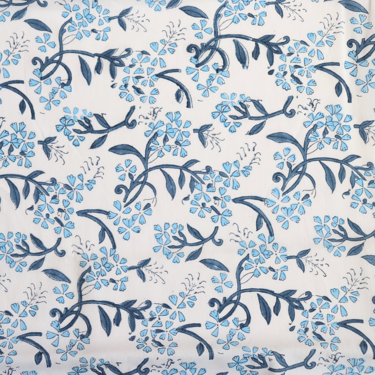 blue and white delicate floral hand block print white cotton dressmaking and quilting fabric