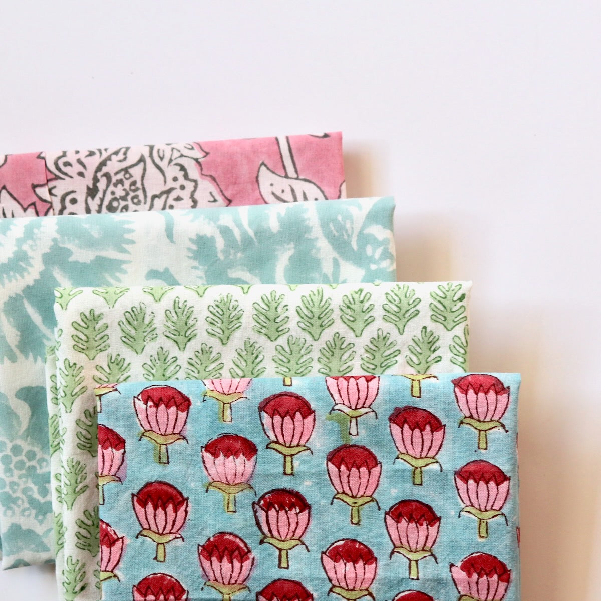 bundle of hand print cotton fabrics in bright pastel colors for quilting and crafts