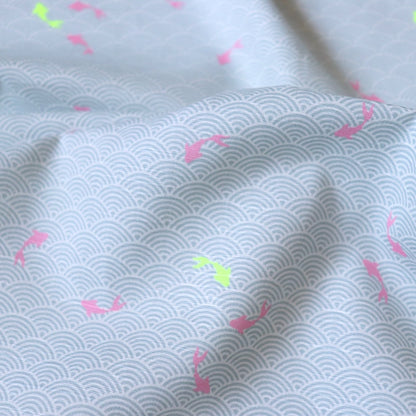 Japanese wave-print fabric with leaping koi fish pink and yellow on grey cotton 