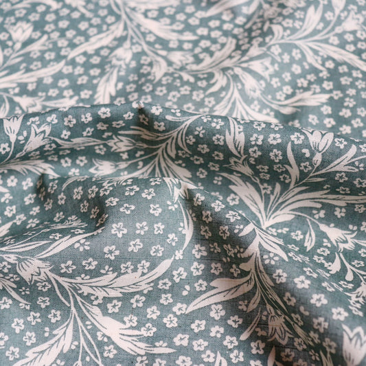 green linen cotton fabric with wispy floral print in woodblock style