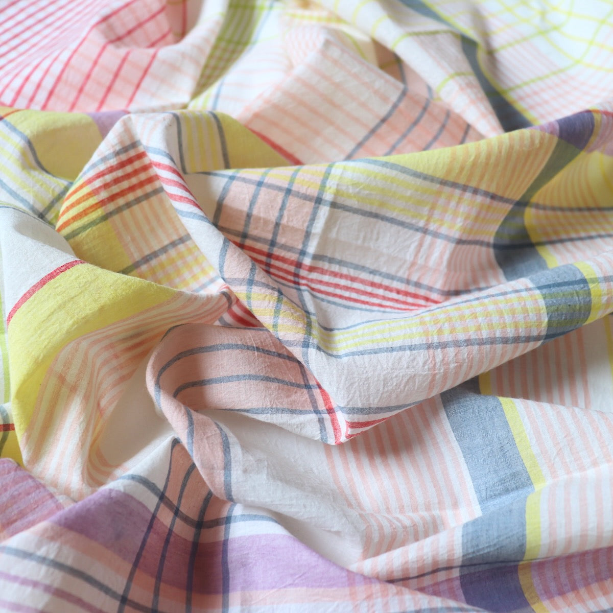 white cotton fabric with yarn-dyed large scale check design in red pink and yellow handwoven in India