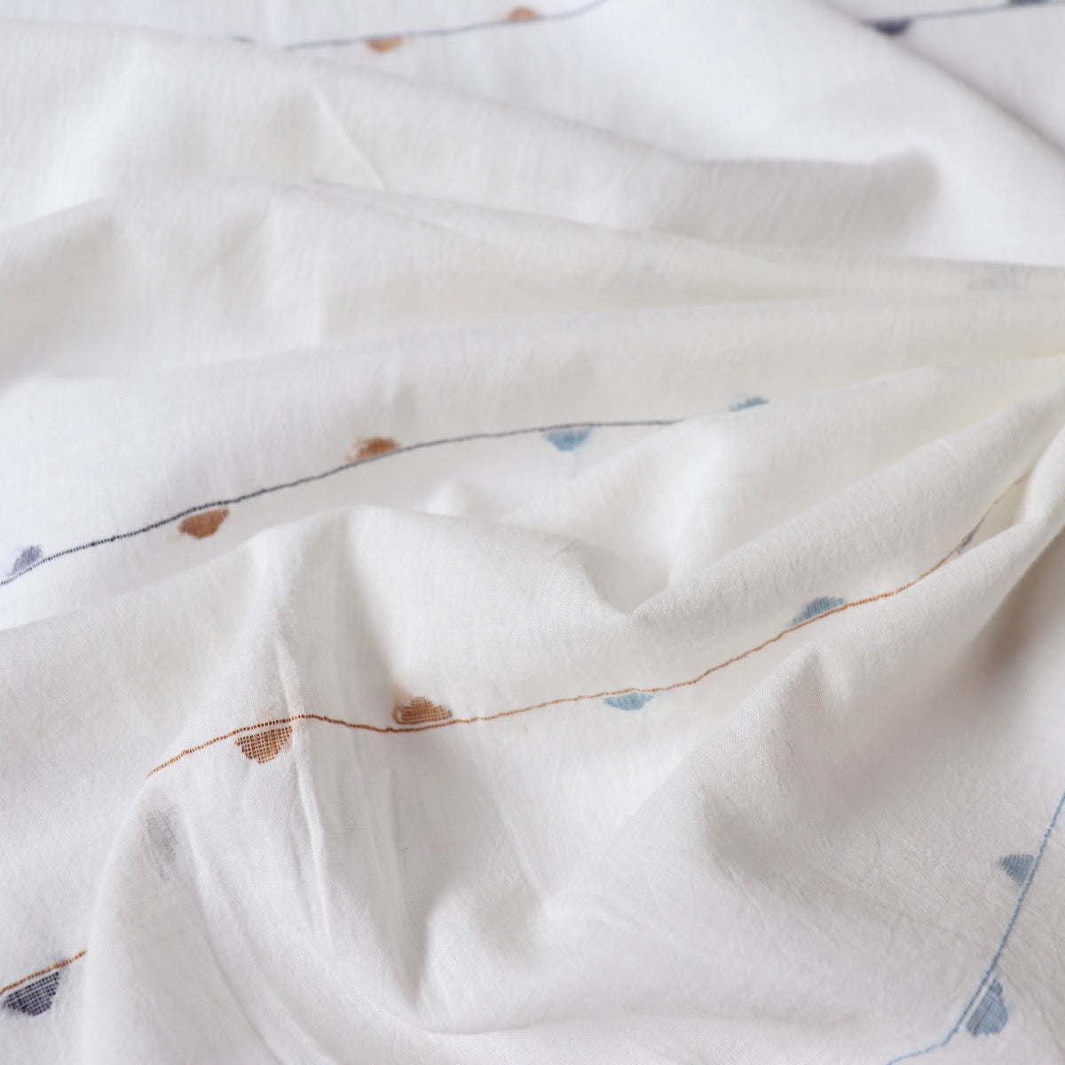super soft cotton fabric handwoven with blue geometric designs on white jamdani muslin