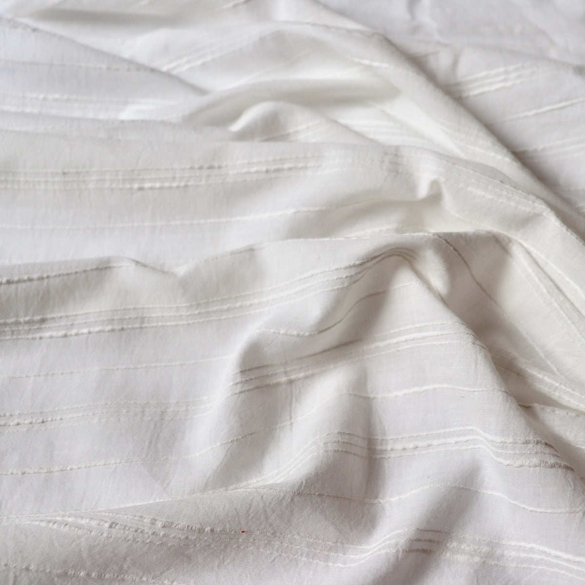 soft white handwoven cotton fabric with textured slub stripe by the yard